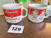 Front view of both Campbell's mugs showing distinct graphics