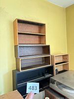 Stack of five wooden CD racks showing assorted finishes and sizes