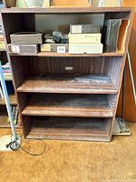 Front view of wooden laminate bookshelf showing shelves and cable cutout