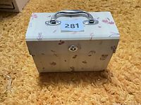 Rectangular document organizer with chrome handle and latch, butterfly and floral pattern on exterior