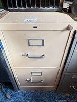 Front view of HON beige 2-drawer filing cabinet showing handles, label frames and lock