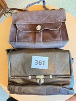 Two handbags on table, top suede boxy bag, bottom dark brown flap bag