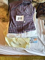 Stack of assorted shirts with lot tag