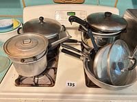 Overview of all pots, pans, lids and utensils on stovetop