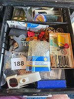 Drawer view showing rulers, magnifiers, push pins, tacks, staples, clips and other small office items