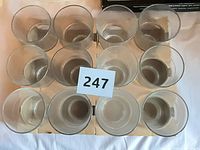 Top view of twelve identical clear glass tumblers arranged in rows