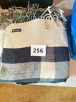 Folded green navy cream tartan plaid scarf showing brand tag and fringe