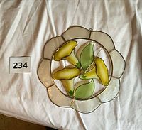 Front view of circular stained glass panel with yellow flowers and green leaves