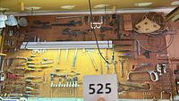 Wide view of pegboard with various hand tools including saws, chisels, screwdrivers, pliers and hammers