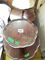 Top view showing both two-tier scalloped wooden tables stacked, visible scratches and measurement notes