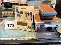 Polaroid SX-70 Land Camera folded open with GE Flash Bar II package