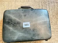 Top view of grey hard-sided suitcase showing exterior scuffing