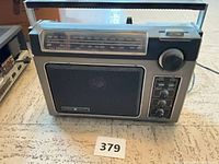 Front view showing speaker grille, tuning window, knobs and handle