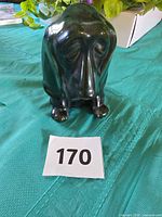 Front view of green/black drip-glaze ceramic basset hound coin bank with lot number card