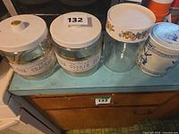 Four storage jars lined on countertop showing sizes and designs