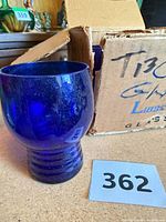 Single cobalt blue pedestal tumbler in front of original Libbey shipping box, lot reference card visible
