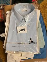 Stack of shirts with sealed Ketch dress shirt on top