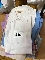 Stack of vintage men’s button-down shirts in various colors with lot sticker
