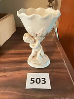 Front view of white cherub pedestal compote showing overall form