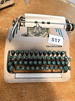 Front view of beige Smith-Corona portable typewriter showing keyboard and branding