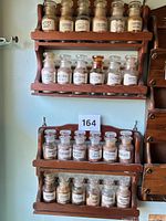 Overall view of two wooden racks with glass spice bottles mounted on wall