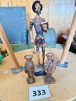 Front view of Don Quixote figurine flanked by two smaller wooden figures