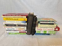 Two stacks of assorted books showing spines, bibles and hymnary visible