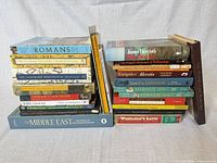 Two stacks of assorted books showing spines and subjects