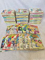 Stacks and spread of approximately 80 Archie digest comics showing various series and visible wear