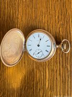 Watch open showing dial with Roman numerals and sub-seconds