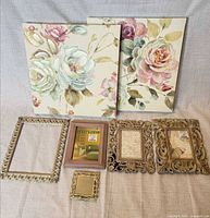Full lot showing two floral canvases and five frames