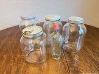 Front view of four canning jars and decorative bottle