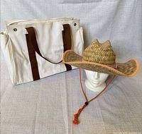 Canvas tote and straw hat displayed together