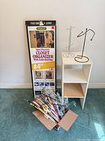 Full lot showing boxed closet organizer, cube shelf, box of hangers, two jewelry stands