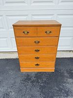 Front view showing all five drawers and brass-tone pulls