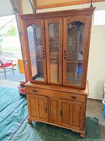 Front view showing glass upper section, drawer, lower cabinet