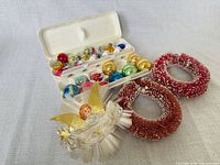 Lot overview: glass ornaments in plastic tray, two red wreaths, white angel wreath