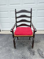 Front view of ladderback armchair with red cushion