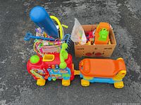 Ride-on train engine, wagon, storage bin, cardboard box of vehicles