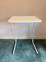 Front view of white folding adjustable TV tray table fully assembled