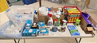 Overall view of table with bulbs, sprays, trash bags, mop