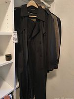 Black trench coat hanging with others
