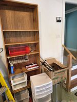 Wood bookshelf with bins and dish rack visible