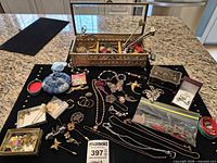 Overall lot on black cloth showing jewelry pieces and boxes