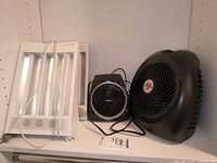 Two SunTouchPlus lamps, small and mid-size Vornado fans on shelf