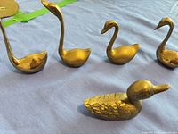 Group view of five brass bird figurines