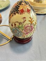 Floral cloisonné-style egg on wooden stand