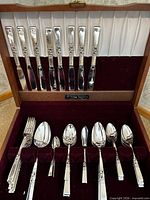 flatware set in wooden chest showing knives, forks and spoons