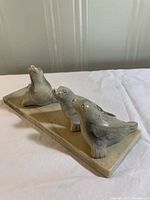 angled view of ceramic figurine with three seals on base