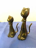 Front view of both brass cat figurines